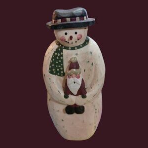 Wood snowman holding santa in his hands